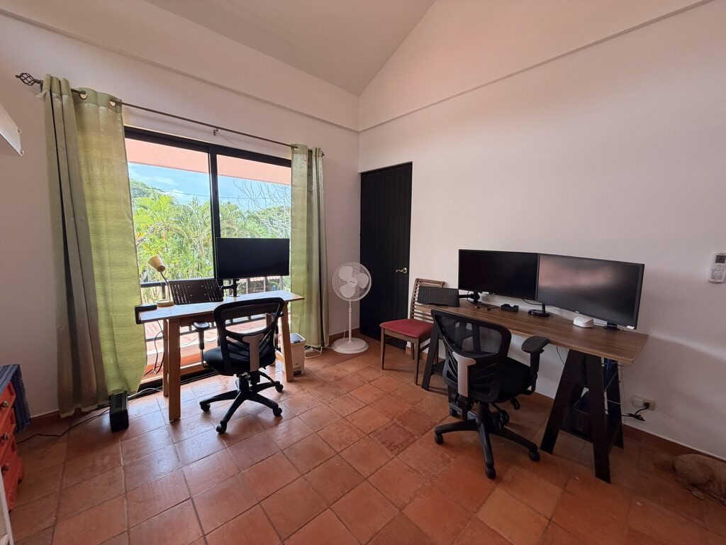 Office with two desks and monitors facing the garden