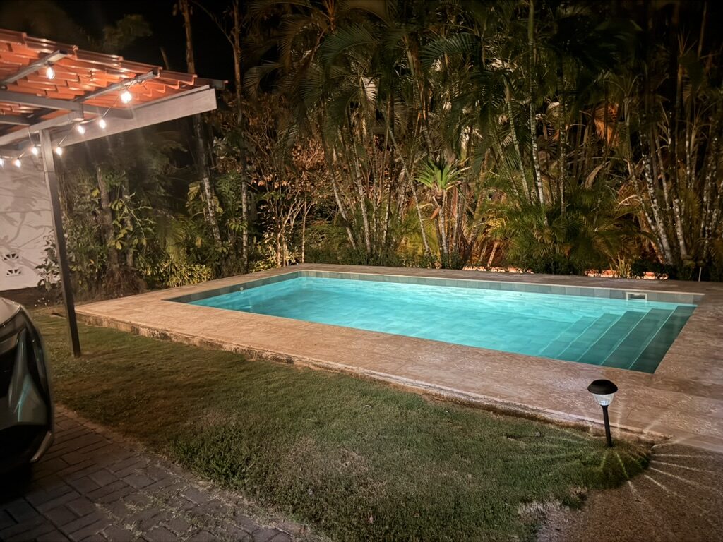 The pool lit at night against the palms